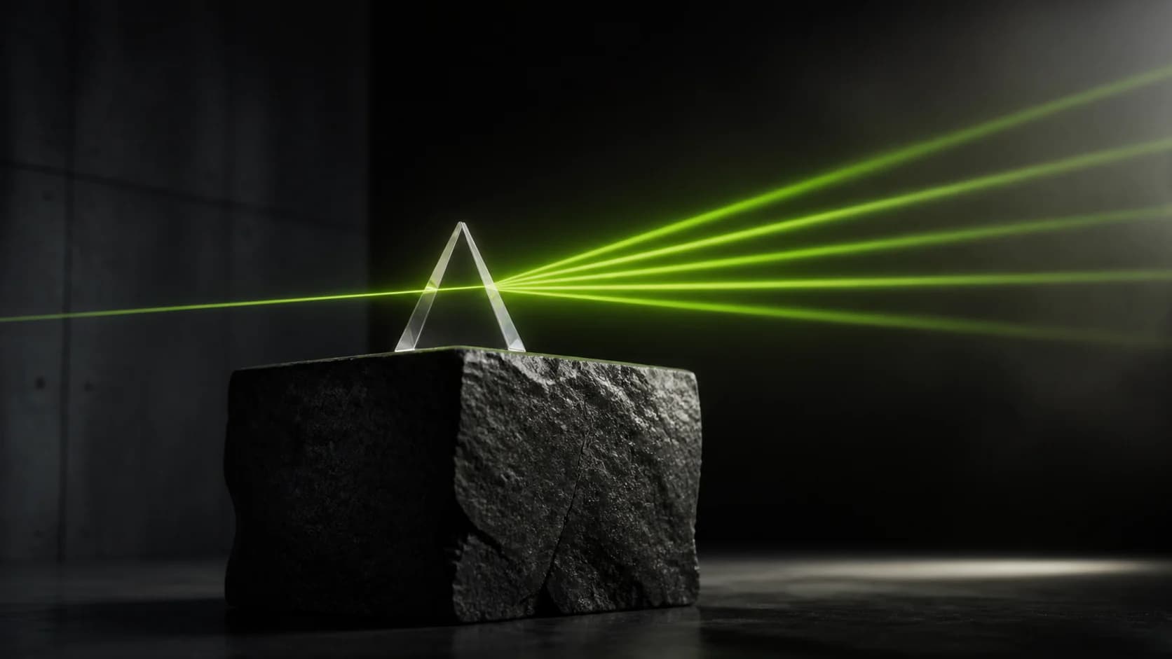 A clear glass prism on a dark stone foundation splitting a lime beam into multiple rays
